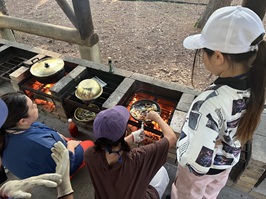 スパゲッティを火起こし場で炒めている様子