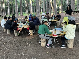 自分たちで用意したテーブルとイスで夕食をとっている様子