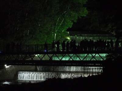 水管橋からライトアップされた水すだれを見る市民