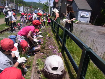 地域の小学生と花を植える様子